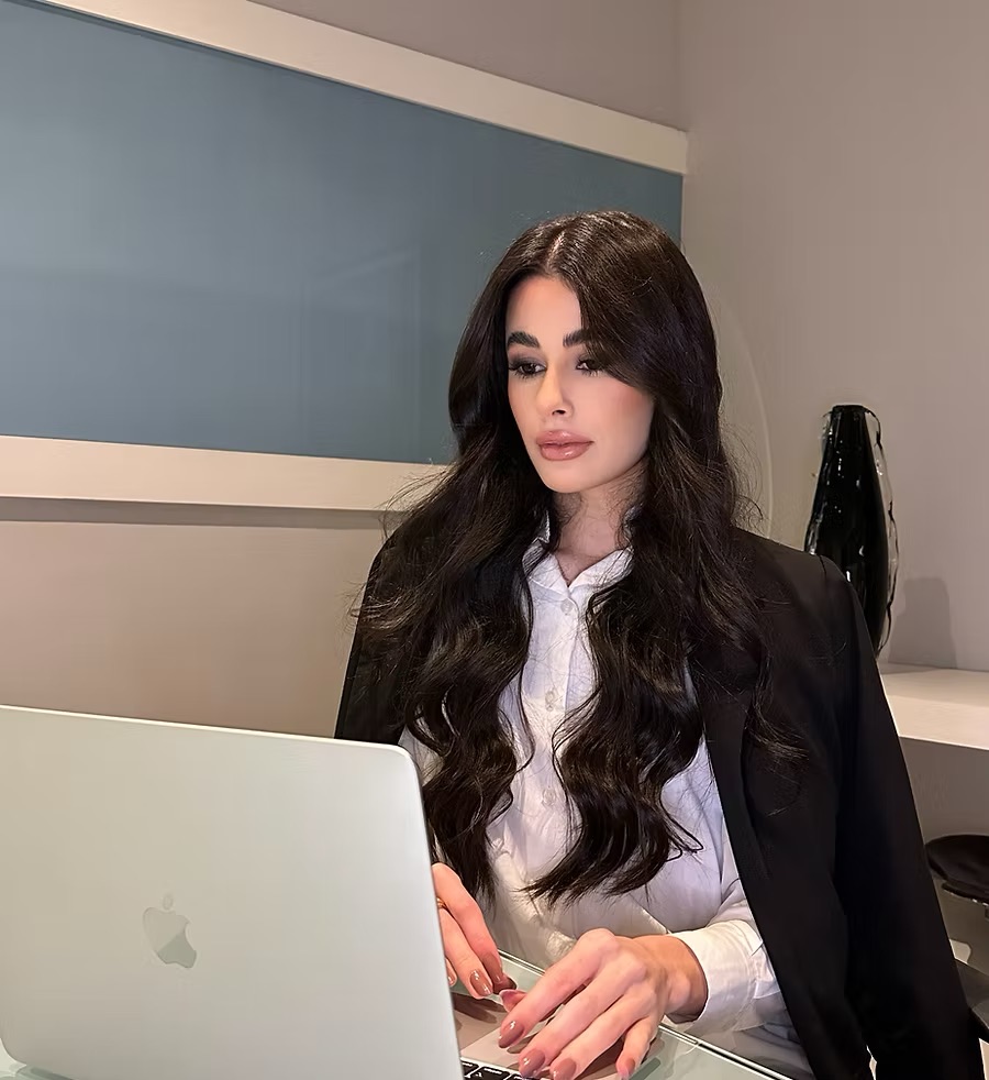 Foto da Dra. Grazielly Pereira trabalhando em seu notebook